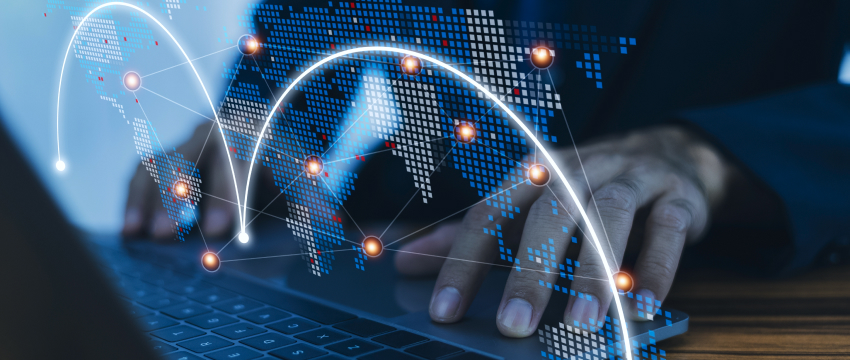 Empresário usando um laptop com um mapa-múndi exibido, concentrado na análise do mercado Forex